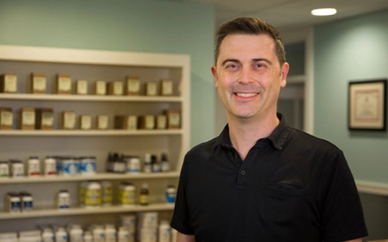 Dr. Michael Kennedy stands in a professional clinic environment.