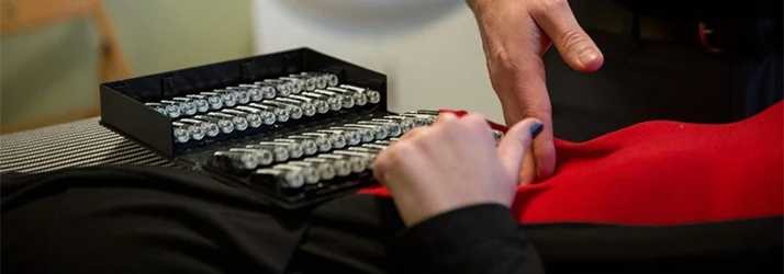 Practitioner selecting homeopathic ampoules for a customized wellness or nutritional assessment.
